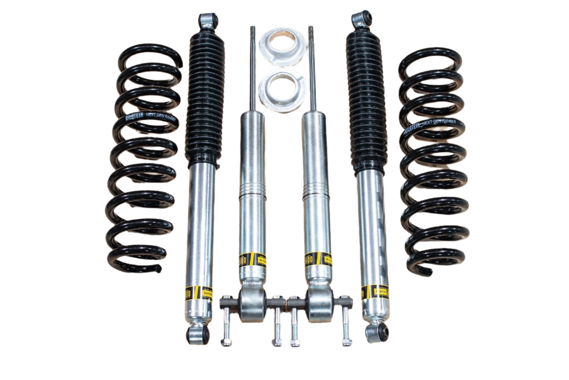 Set of car suspension components including shock absorbers and springs on a white background