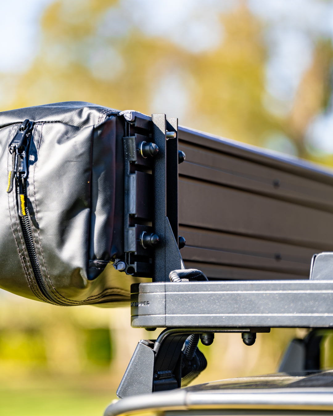 close up of roof rack and brackets attaching rooftop tent to the car